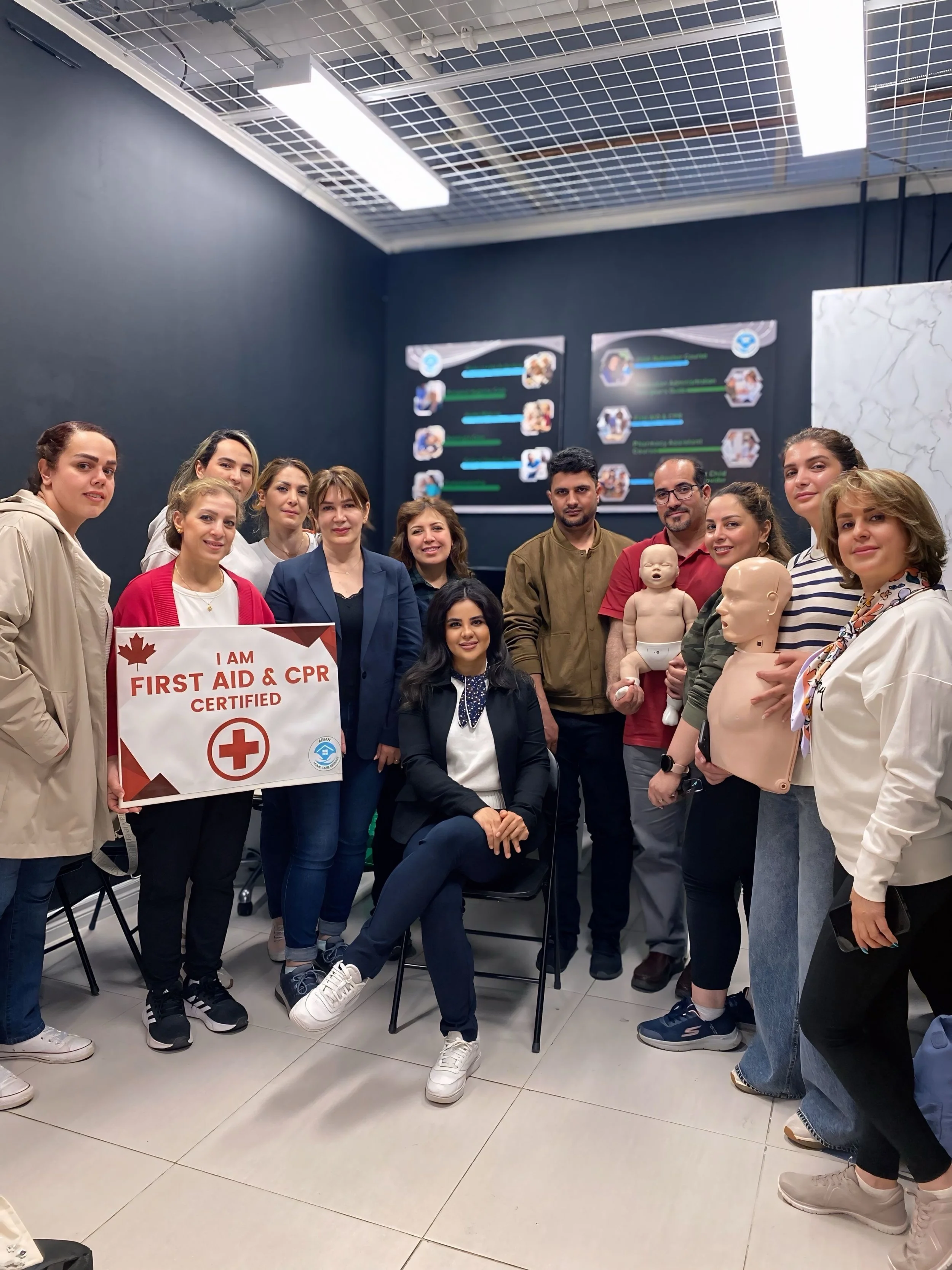 First Aid and CPR training participants posing with certification equipment and training mannequins